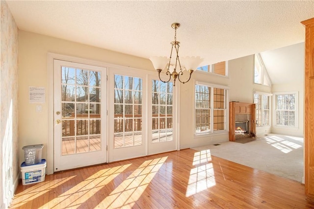 doorway with a healthy amount of sunlight, a chandelier, and light hardwood / wood-style floors