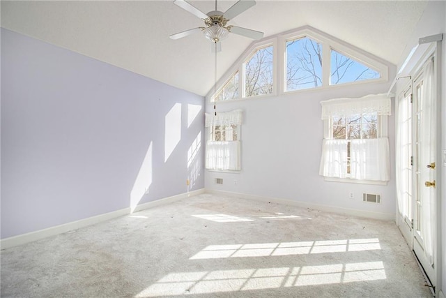 empty room featuring ceiling fan, high vaulted ceiling, and light carpet