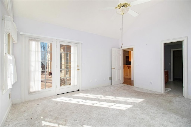 empty room featuring ceiling fan, light carpet, and high vaulted ceiling