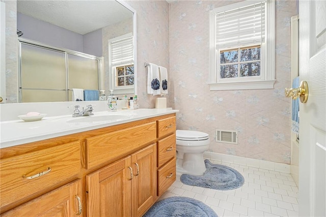 bathroom featuring a shower with shower door, tile patterned floors, vanity, and toilet