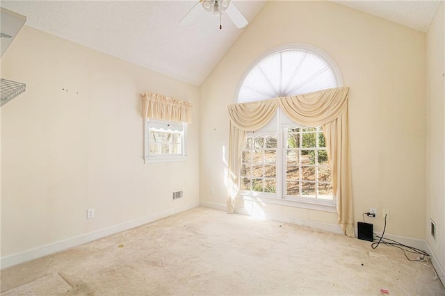 carpeted spare room featuring ceiling fan and vaulted ceiling