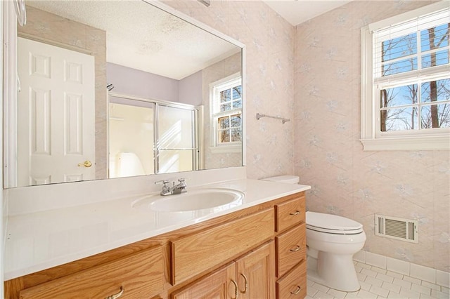 bathroom featuring walk in shower, vanity, tile patterned flooring, and a wealth of natural light