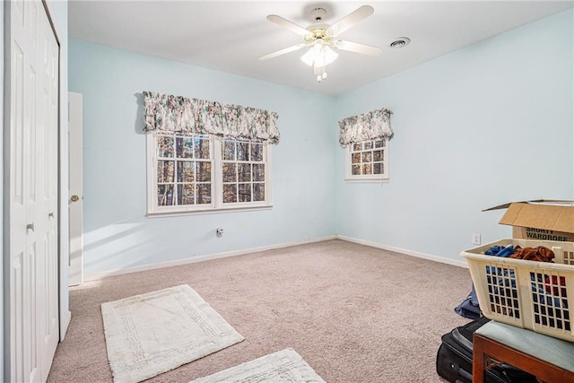 interior space with ceiling fan and carpet