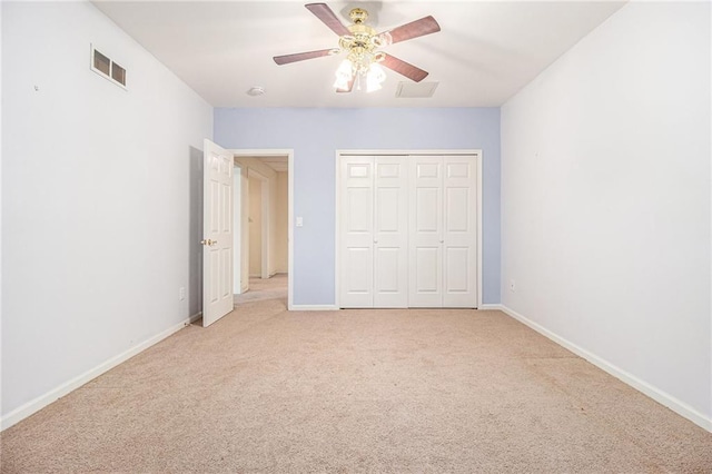 unfurnished bedroom with ceiling fan, light colored carpet, and a closet