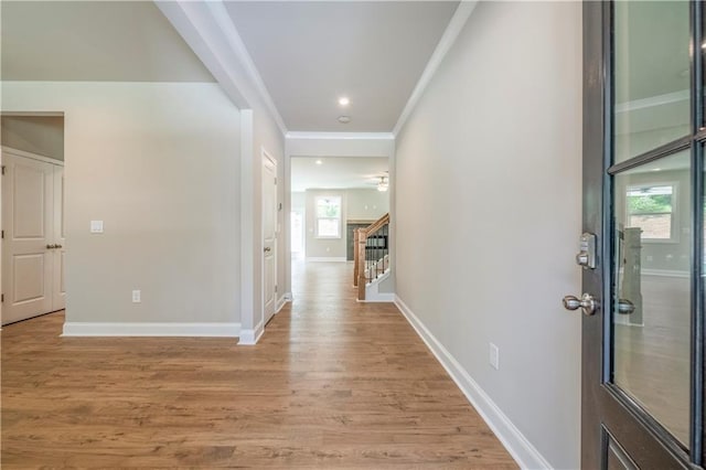 hall featuring light hardwood / wood-style flooring and ornamental molding