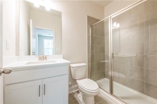 bathroom with tile patterned flooring, toilet, walk in shower, and vanity