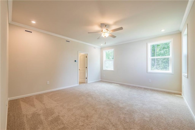 spare room featuring ceiling fan, light colored carpet, and ornamental molding