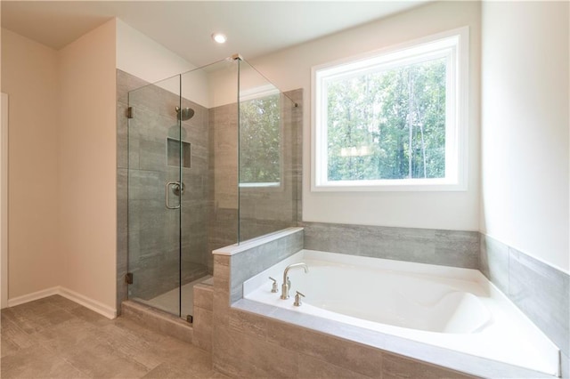 bathroom featuring independent shower and bath and a wealth of natural light