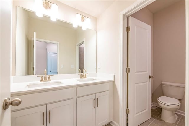 bathroom with toilet, tile patterned floors, and vanity