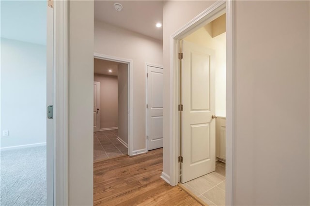 hallway with light hardwood / wood-style floors