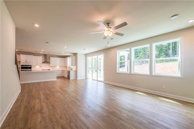 unfurnished living room featuring ceiling fan, plenty of natural light, and light wood-type flooring