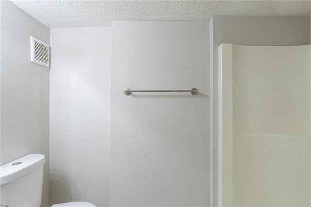 bathroom with toilet and a textured ceiling