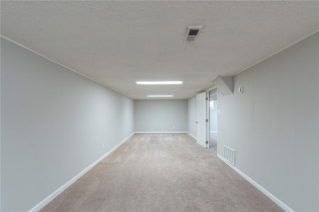 spare room with light colored carpet and a textured ceiling