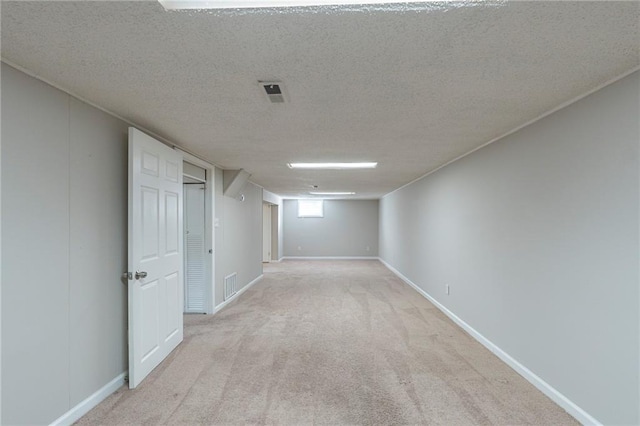 basement with light colored carpet and a textured ceiling