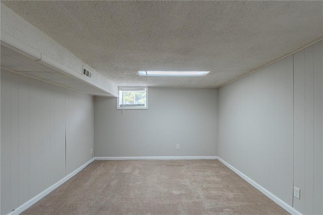 basement with a textured ceiling and light carpet