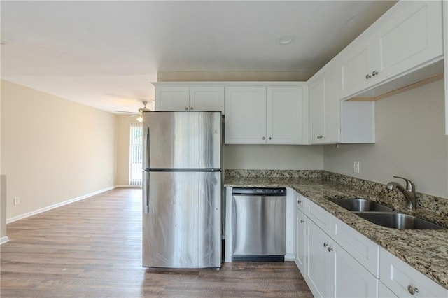 kitchen featuring sink, stainless steel appliances, light stone counters, and white cabinets