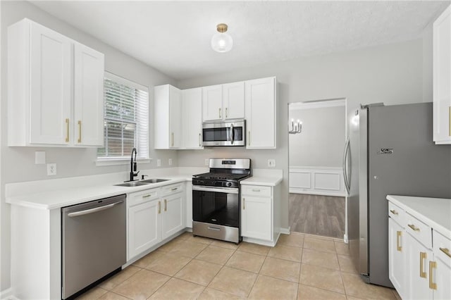 kitchen with a sink, light countertops, white cabinets, and stainless steel appliances