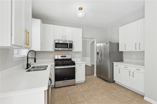 kitchen featuring light countertops, white cabinetry, appliances with stainless steel finishes, and a sink