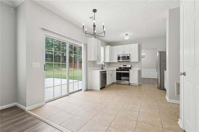 kitchen featuring a sink, light countertops, stainless steel appliances, baseboards, and visible vents