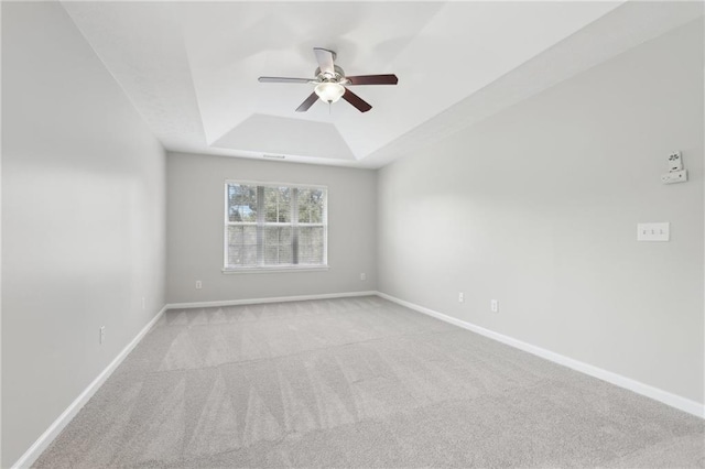 unfurnished room featuring baseboards, carpet, ceiling fan, and a tray ceiling