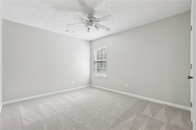 carpeted empty room featuring a ceiling fan, baseboards, visible vents, and a textured ceiling