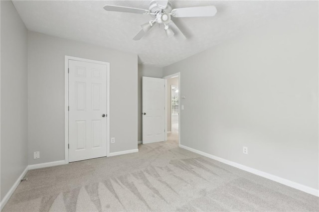 unfurnished bedroom featuring carpet floors, baseboards, and ceiling fan