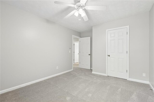 unfurnished bedroom with baseboards, ceiling fan, carpet, and a textured ceiling