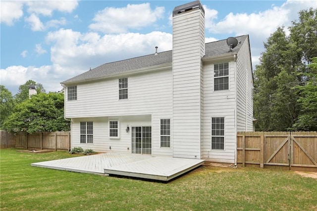 rear view of property featuring a yard, a wooden deck, a fenced backyard, and a chimney