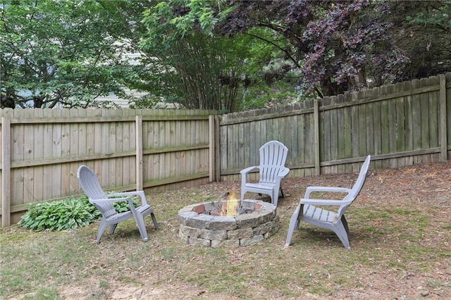 view of yard with a fenced backyard and a fire pit