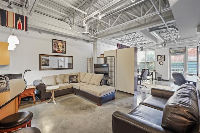 living room featuring ceiling fan and concrete flooring