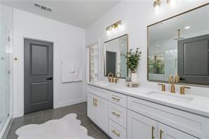 bathroom with a sink, tile patterned flooring, double vanity, and a freestanding bath