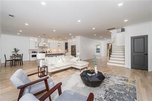 living area featuring baseboards, visible vents, wood finished floors, and a glass covered fireplace