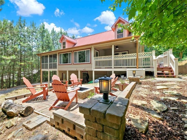 back of property featuring a sunroom, a patio area, and a fire pit