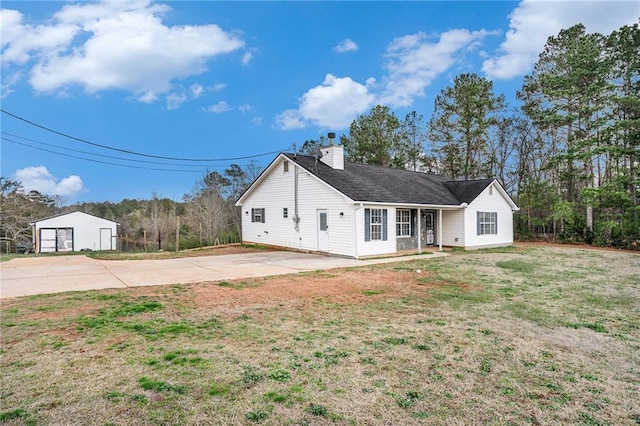 view of front of home featuring a garage, roof with shingles, a chimney, and a front lawn