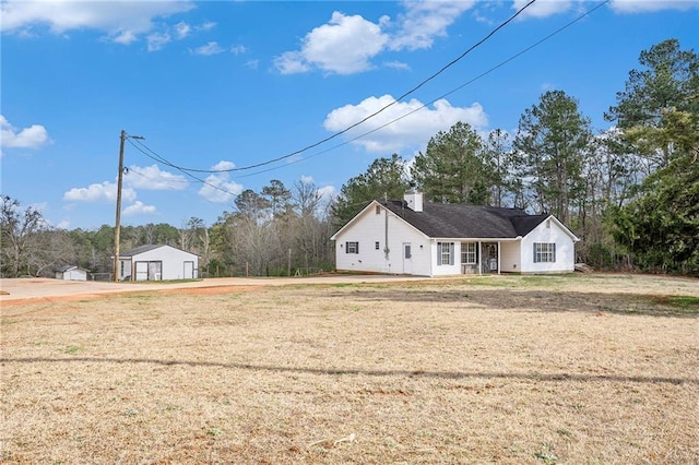 view of yard with a garage and an outbuilding