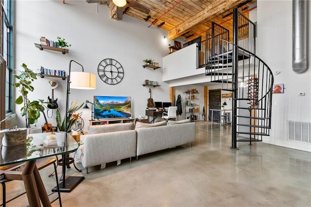 living room with a towering ceiling, brick ceiling, ceiling fan, beam ceiling, and concrete flooring