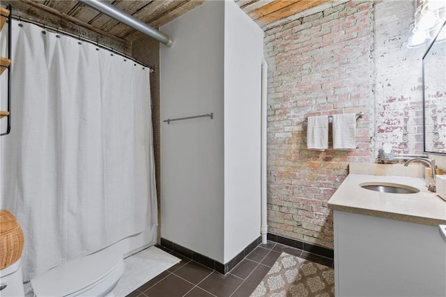 bathroom with curtained shower, tile patterned flooring, brick wall, and vanity