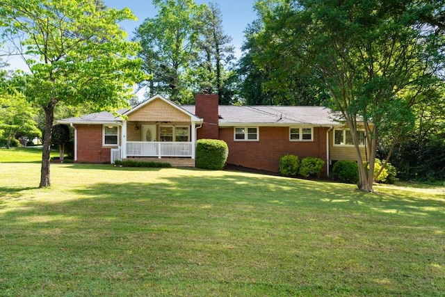 single story home with covered porch, a chimney, and a front lawn