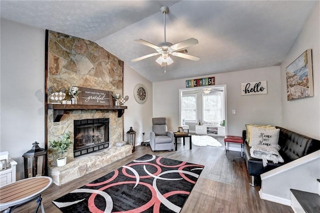 living room with hardwood / wood-style floors, vaulted ceiling, a fireplace, and ceiling fan