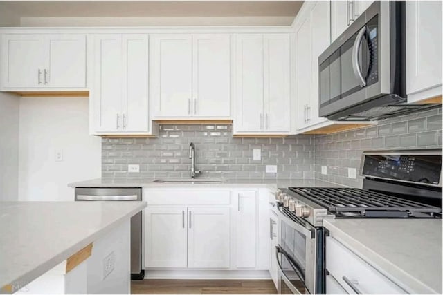 1648 Florence Run NW, Atlanta, GA 30318 - kitchen with appliances with stainless steel finishes, light countertops, white cabinetry, and tasteful backsplash