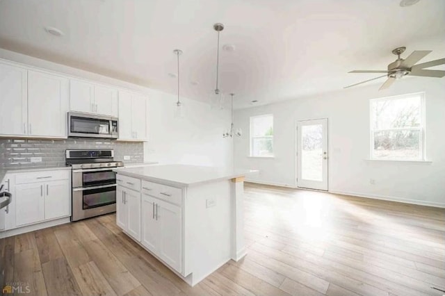 1648 Florence Run NW, Atlanta, GA 30318 - kitchen with appliances with stainless steel finishes, light countertops, light wood-style floors, and ceiling fan