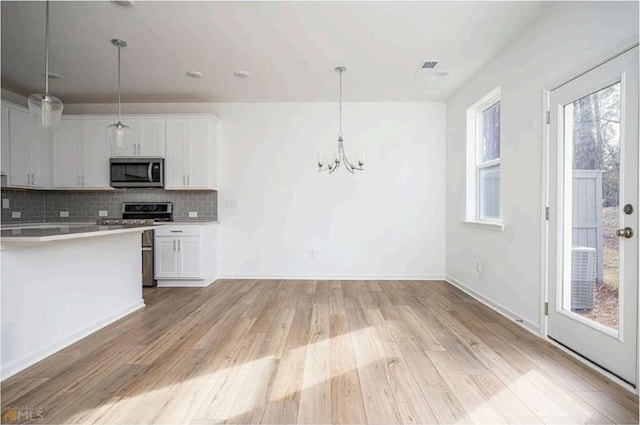 1648 Florence Run NW, Atlanta, GA 30318 - kitchen featuring stainless steel appliances, white cabinets, light wood-style floors, and decorative backsplash