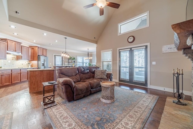 living area with recessed lighting, light wood-style flooring, ceiling fan with notable chandelier, and a wealth of natural light