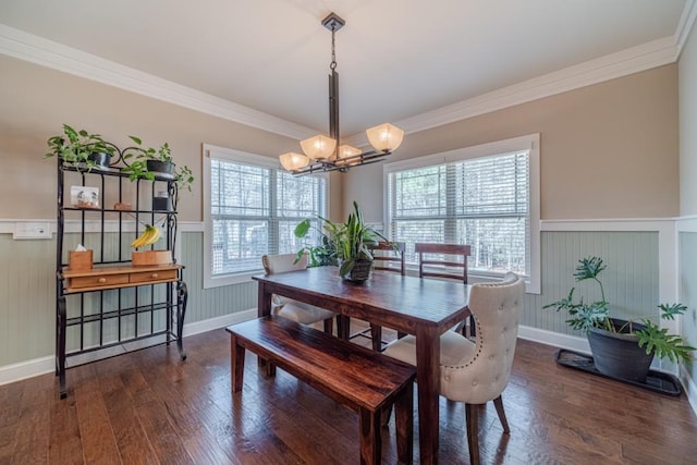 dining room with wainscoting, wood finished floors, and a notable chandelier