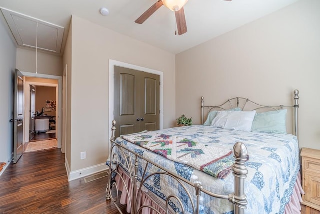 bedroom featuring a ceiling fan, baseboards, wood finished floors, and attic access