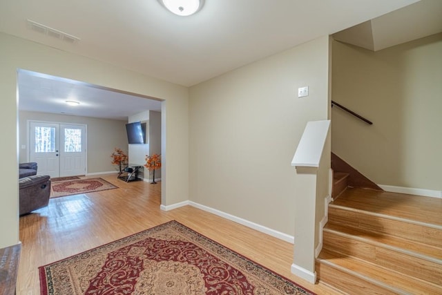 interior space featuring stairs, baseboards, visible vents, and wood finished floors
