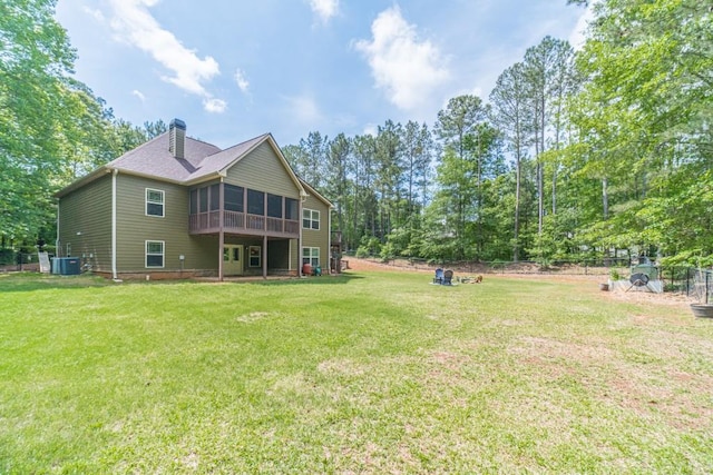 back of house with a sunroom, a lawn, a chimney, and cooling unit