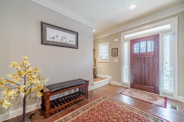 entrance foyer featuring visible vents, crown molding, wood finished floors, baseboards, and recessed lighting