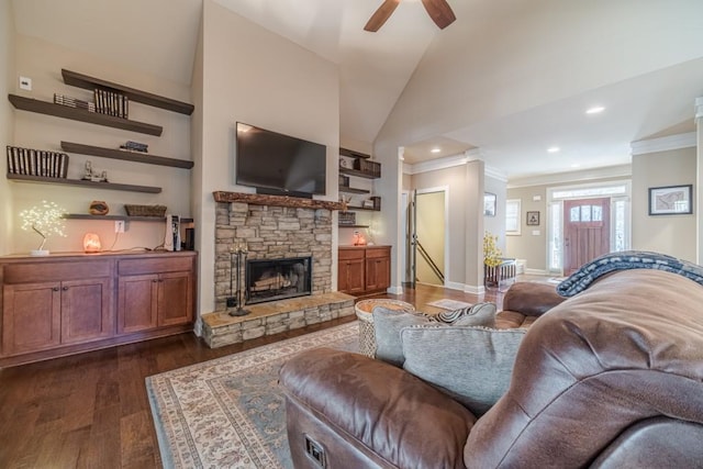 living area with a ceiling fan, crown molding, a fireplace, lofted ceiling, and dark wood-type flooring