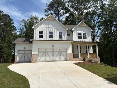 30 Riverrock Trl, Dallas, GA 30157 - modern farmhouse featuring a porch, board and batten siding, concrete driveway, a garage, and a front lawn